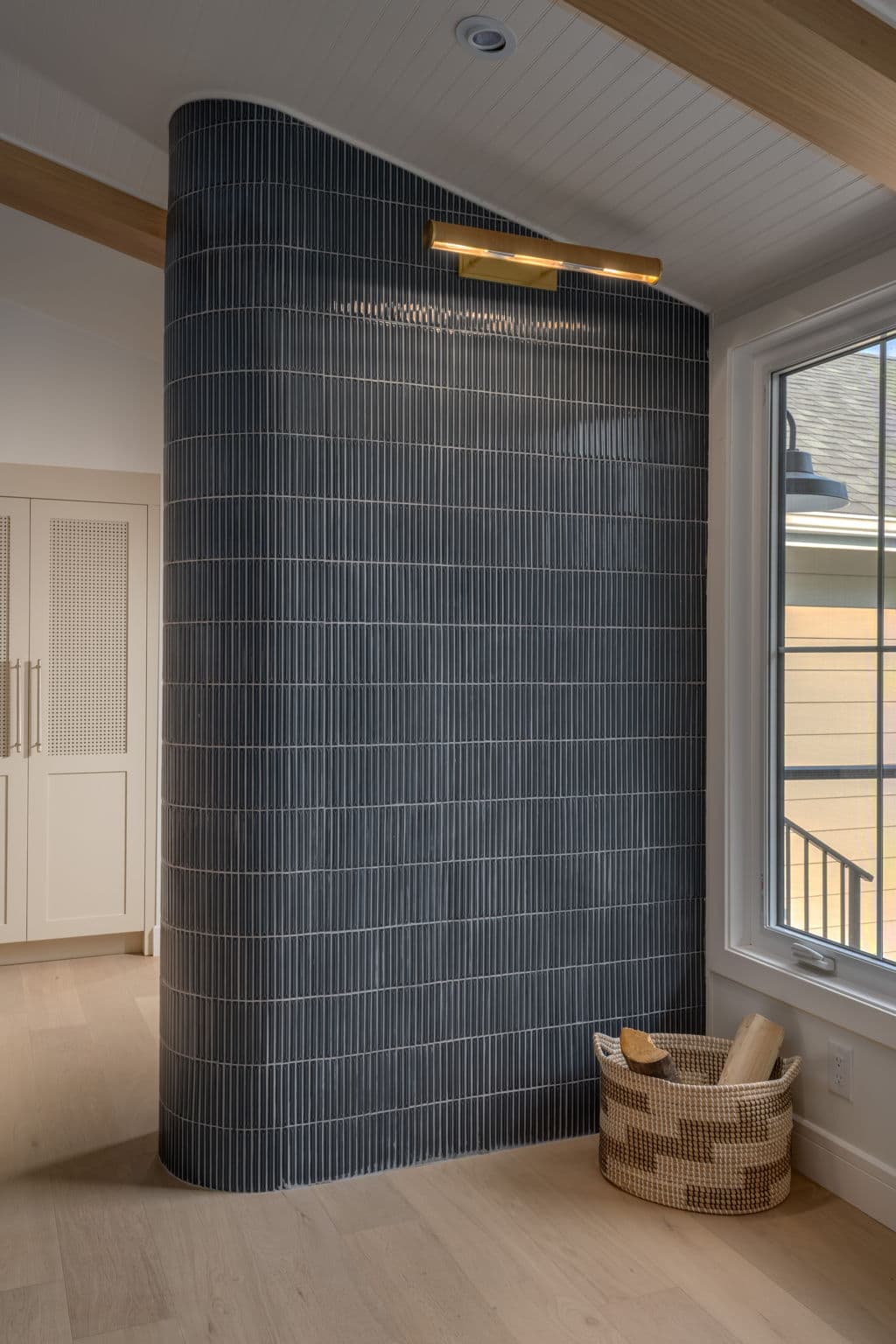 Curved entry wall wrapped in deep blue tile in the Varal Road renovation by Platinum Build Homes in Varsity, Calgary.