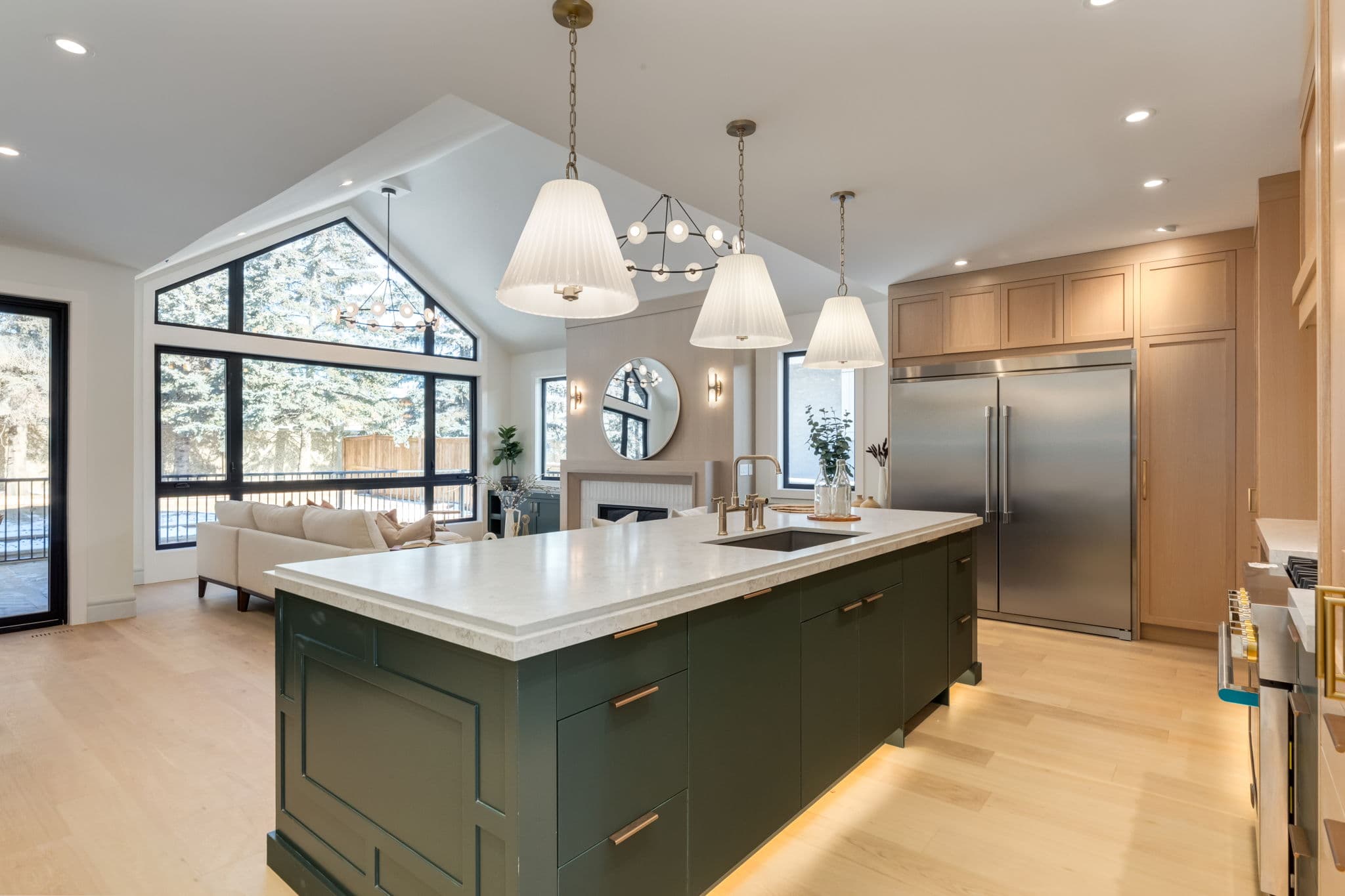 Kitchen island and vaulted living area in the Varsity 2 project by Platinum Build Homes in Varsity, Calgary.